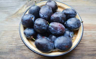 ahşap masa üstünde Erik ile kase