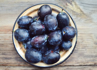 ahşap masa üstünde Erik ile kase