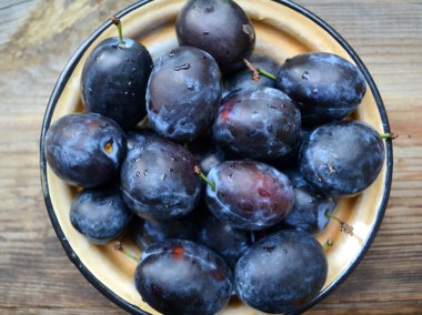 ahşap masa üstünde Erik ile kase