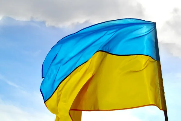 The national yellow and blue flag of Ukraine over the sky and clouds — Stock Photo, Image