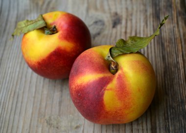 iki sarı ve kırmızı nektarin yapraklarla ahşap tablo