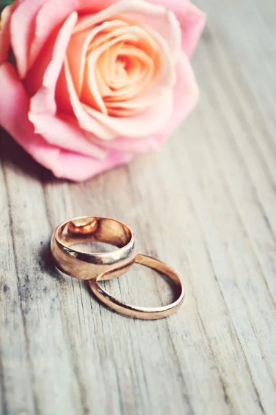 Два обручальных золотых кольца с красивой свадебной розовой розой — стоковое фото