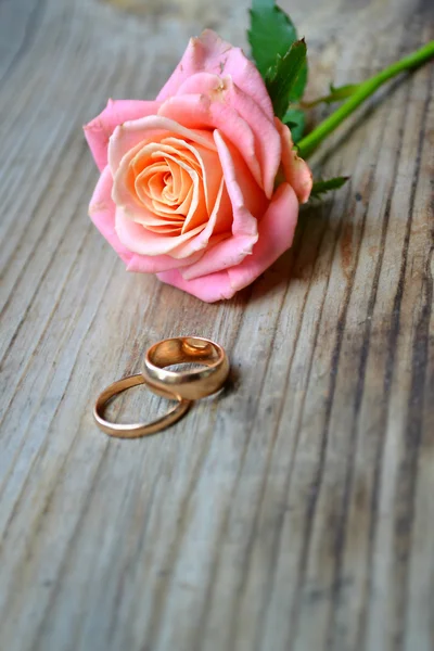 Two engagement golden rings with a beautiful wedding pink rose — Stock Photo, Image