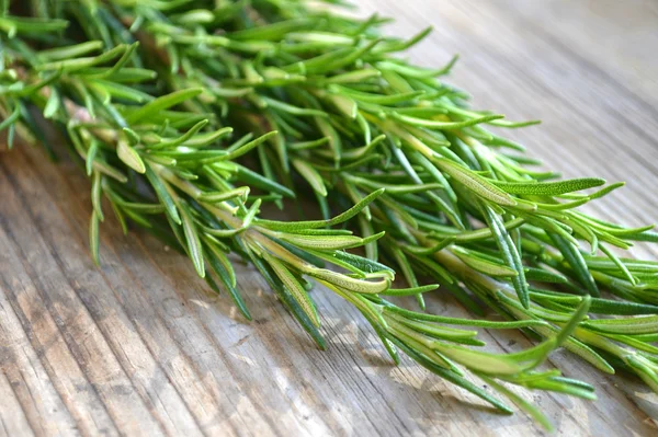 Verse rozemarijn kruid op houten tafel — Stockfoto