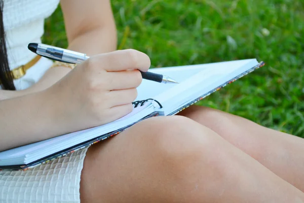 Woman with beautiful hands writing in her diary — Stock Photo, Image