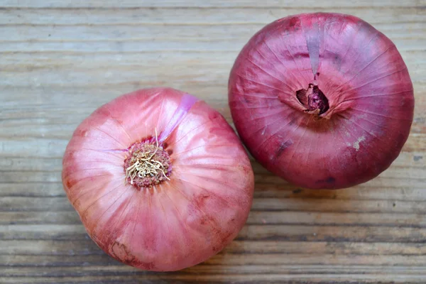 Whole red onions on wooden table — Stock Photo, Image