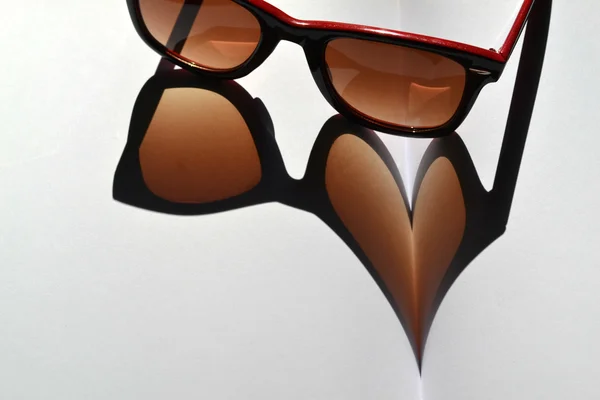 Червоний vintage сонцезахисні окуляри на ноутбук, даючи тінь на серце — Stockfoto