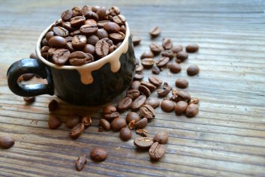 fincan kahve çekirdekleri ahşap masa üstünde dolu