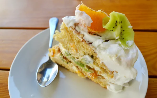 Slice of fruit cake with cream, kiwi and orange — Stock Photo, Image