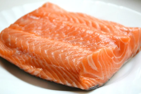 Big piece of salmon fillet on a white plate — Stock Photo, Image