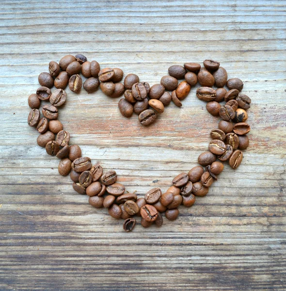 Café asado en forma de corazón sobre fondo de madera — Foto de Stock