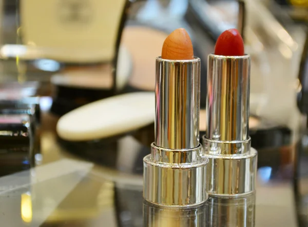 Set of colorful lipsticks with other cosmetics on a dressing table — Stock Photo, Image