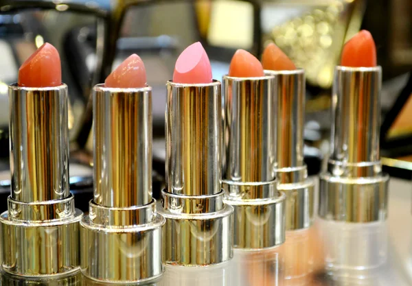Set of colorful lipsticks with other cosmetics on a dressing table — Stock Photo, Image