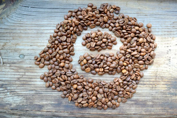 Lettre "e" écrite sur des grains de café sur une table en bois — Photo