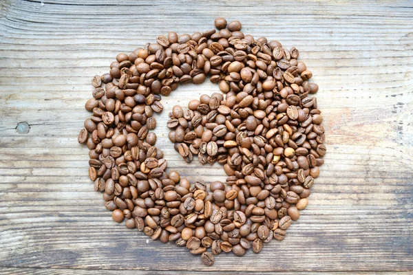 Lettre "c" écrite sur des grains de café sur une table en bois — Photo