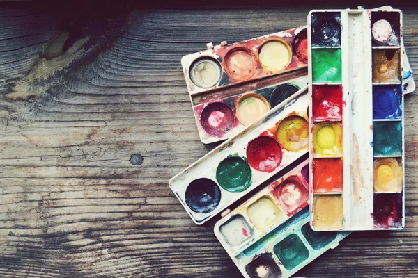 Pinturas y pinceles coloridos dispuestos como un marco en la mesa de madera —  Fotos de Stock