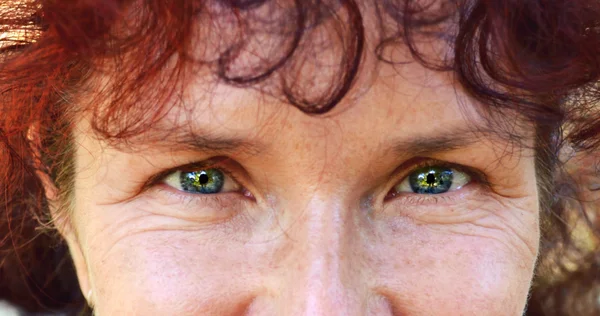 Brillantes ojos azules de una hermosa mujer feliz con el pelo rojo en sus cuarentas — Foto de Stock