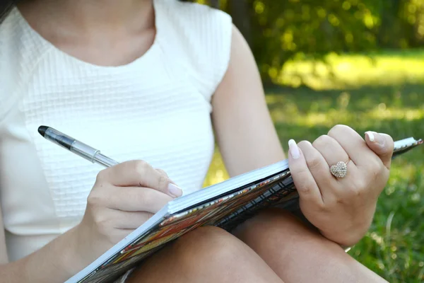 Frau mit schönen Händen schreibt in ihr Tagebuch — Stockfoto