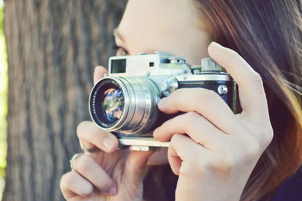 Mujer pelirroja joven con cámara retro tomando fotos — Foto de Stock