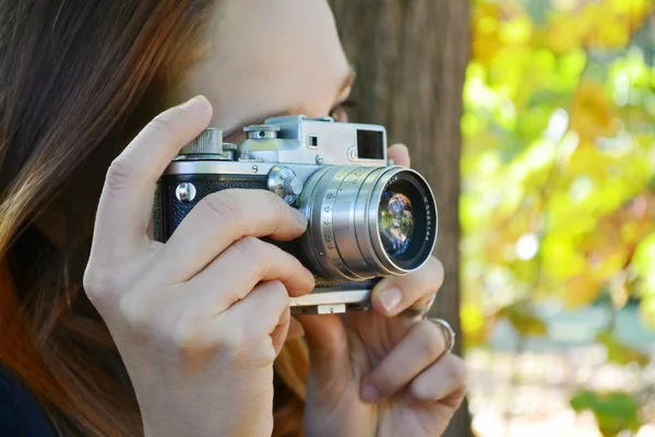 Giovane donna dai capelli rossi con fotocamera retrò scattare foto — Foto Stock