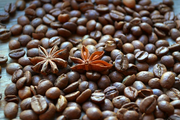 Spicy anise stars on lots of roasted coffee beans — Stock Photo, Image