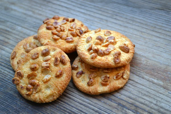 Galletas sabrosas con cacahuetes confitados en mesa de madera —  Fotos de Stock