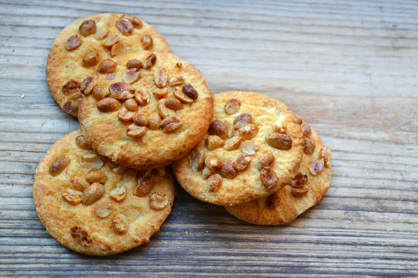 Tasty biscuits with candied peanuts on wooden table — Stock Photo, Image