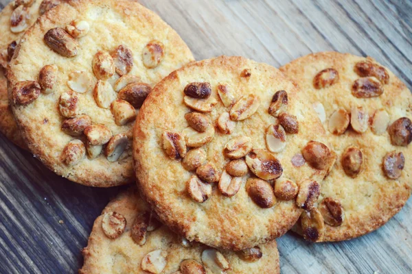 Tasty biscuits with candied peanuts on wooden table — Stock Photo, Image