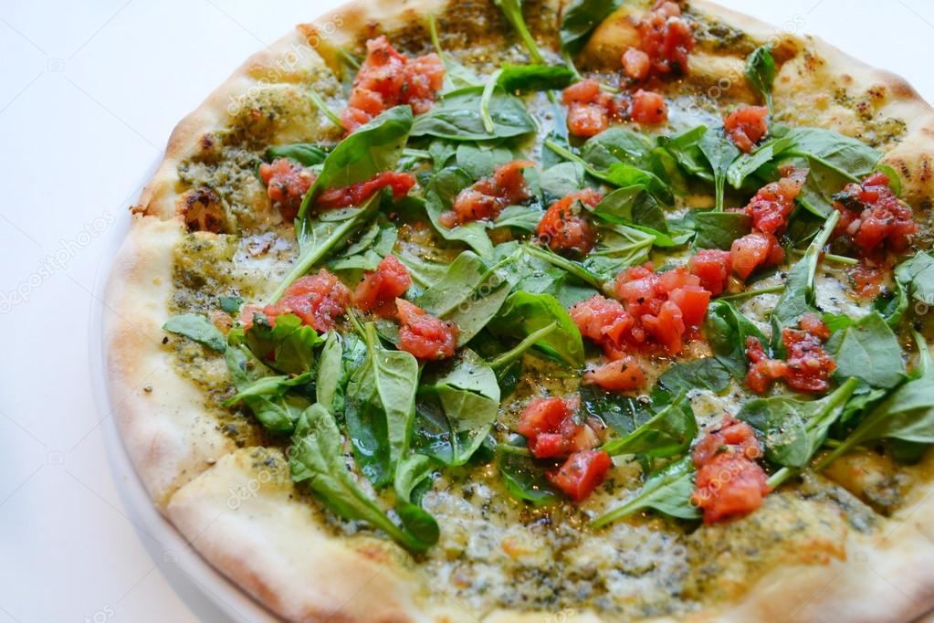 Big round vegetarian pizza with tomatoes and basil
