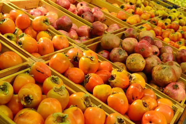 Caqui y granada en la tienda de comestibles — Foto de Stock