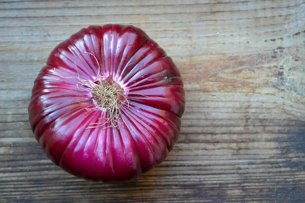 Big red onion on wooden table — Stock Photo, Image