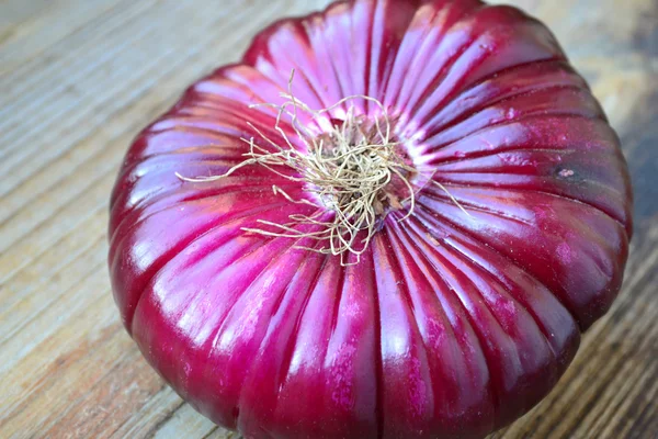 Ahşap masa üzerinde büyük kırmızı soğan — Stok fotoğraf