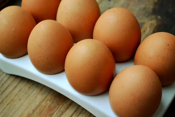 Huevos marrones en una cesta sobre mesa de madera —  Fotos de Stock