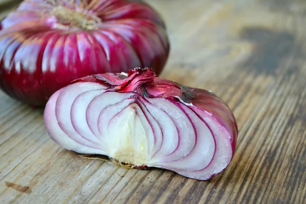 Große rote Zwiebel auf Holztisch — Stockfoto