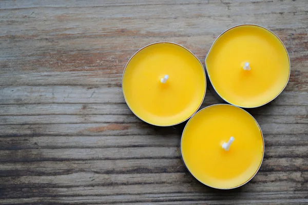 Small yellow candles on wooden table — Stock Photo, Image