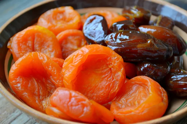 Damascos secos e tâmaras marrons fruta na mesa de madeira — Fotografia de Stock