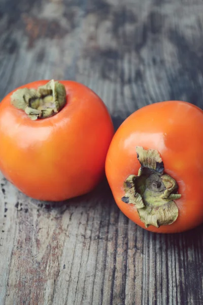 Delicious orange persimmons on wooden table — Stock Photo, Image
