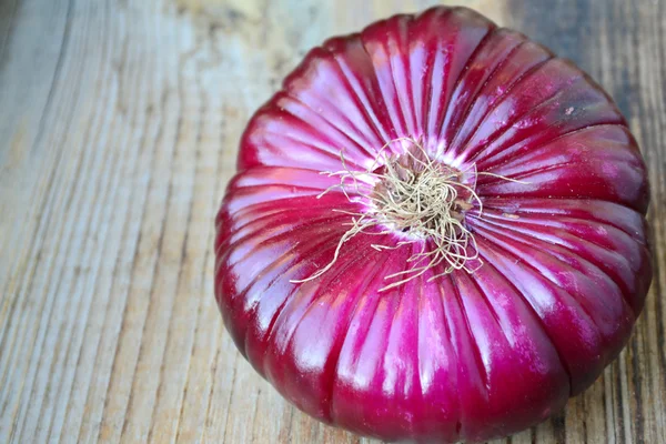 Ahşap masa üzerinde büyük kırmızı soğan — Stok fotoğraf