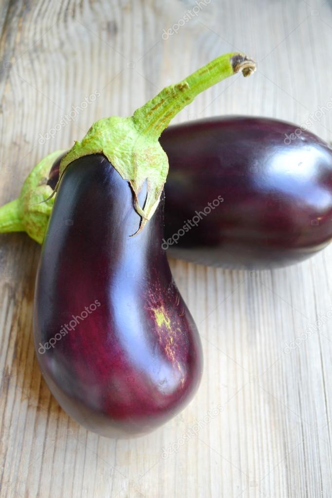 Healthy and delicious purple eggplants on wooden background