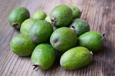 Ahşap masa üzerinde yeşil feijoa meyve