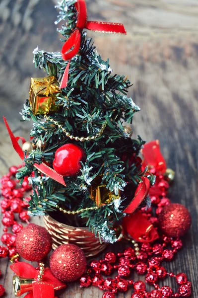 Pequeño árbol de Navidad con decoraciones rojas y doradas — Foto de Stock
