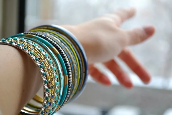 Hand wijzen op iets en dragen van mooie set van dure armbanden van goud — Stockfoto