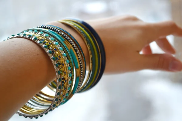 Main pointant vers quelque chose et portant un bel ensemble de bracelets en or coûteux — Photo