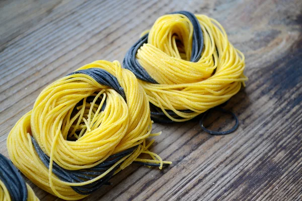 Färgglada okokt italiensk pasta på träbord — Stockfoto