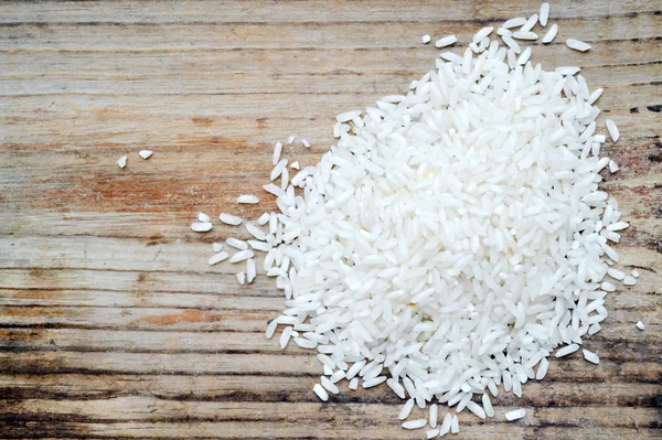 Long grain rice over wooden background — Stock Photo, Image