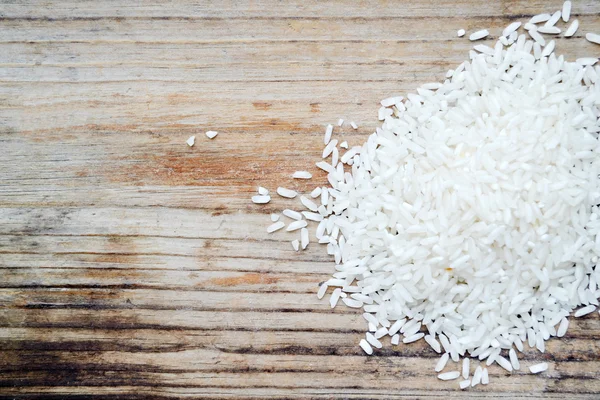 Long grain rice over wooden background — Stock Photo, Image