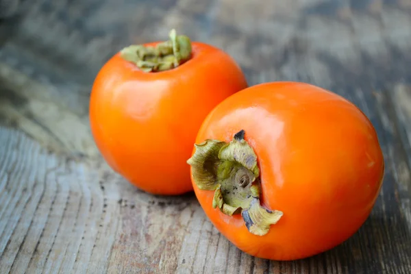 Persimmoni portocalii deliciosi pe masa de lemn — Fotografie, imagine de stoc