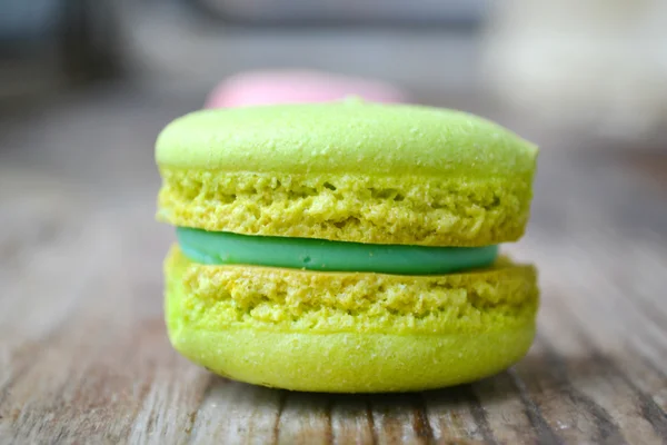 Green French macaron on a wooden table — Stock Photo, Image