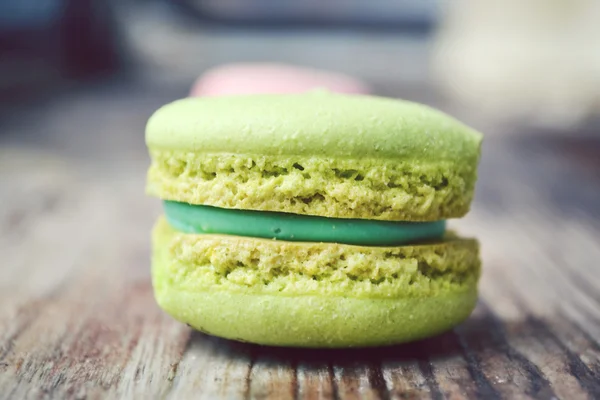 Green French macaron on a wooden table — Stock Photo, Image