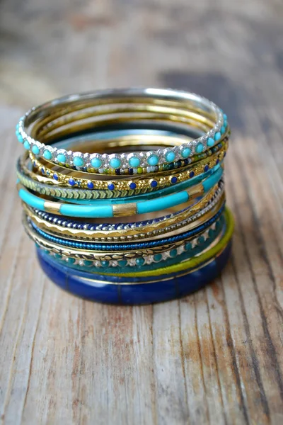 Beaux bracelets en or coûteux sur fond en bois — Photo